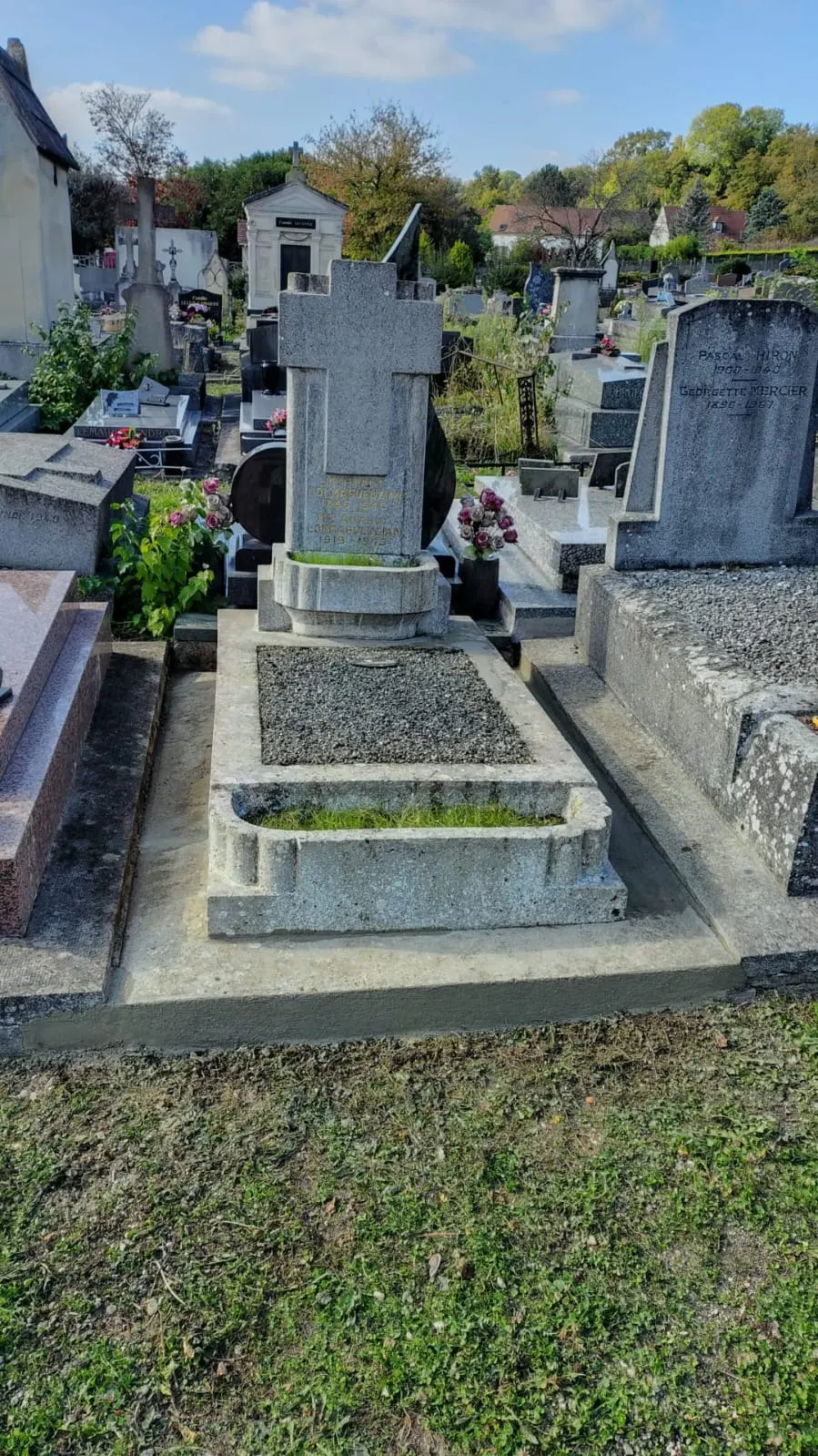 La stèle, les marches et le pourtour apparaissent dégagés et nettoyés ; la forme du monument est conservée.