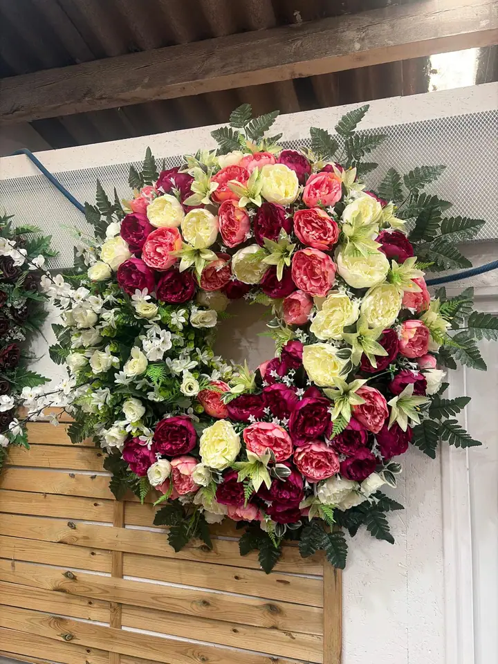 Couronne florale prune, corail et crème avec feuillage vert